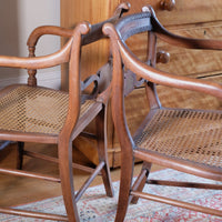 curled back support on a Pair of Regency mahogany armchairs with brass inlay and cane seats, circa 1810