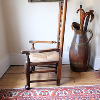 side view baluster-turned leg with a pad foot on a Antique Lancashire Oak Spindle Back Armchair with Rush Seat, 19th Century North Country Chair
