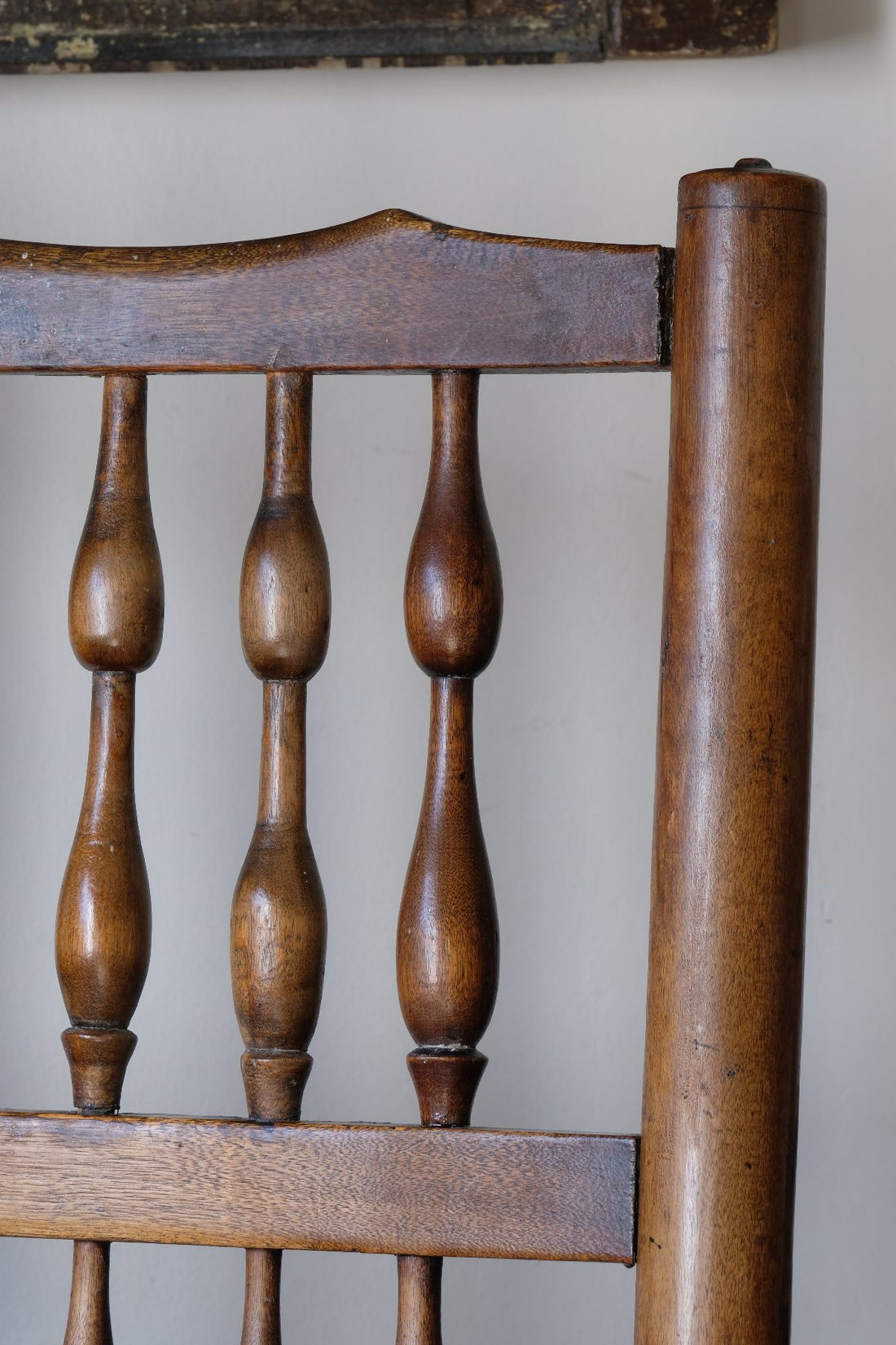 close up of the double baluster spindles back support on an Antique Lancashire Oak Spindle Back Armchair with Rush Seat, 19th Century North Country Chair