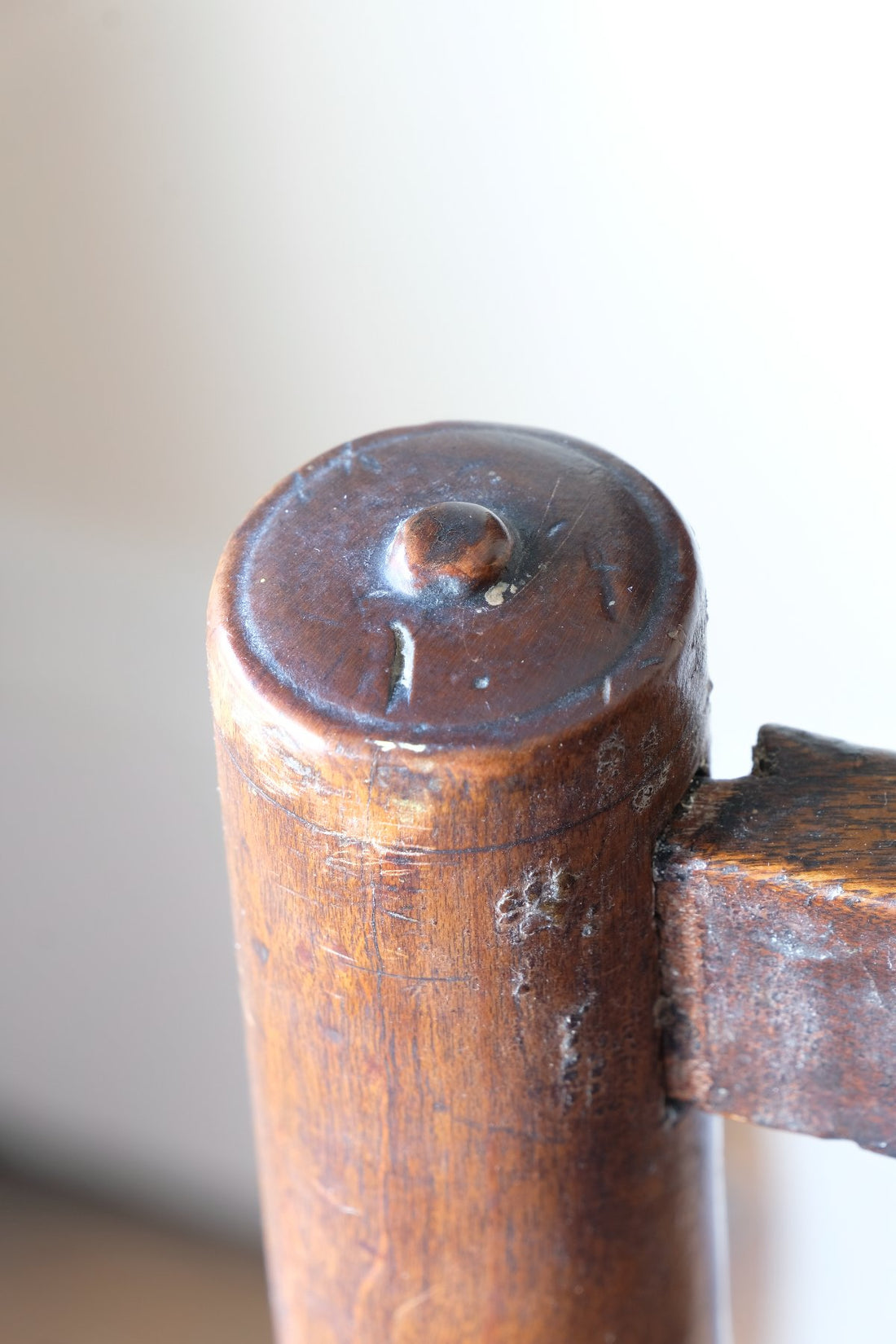 Detail of turned button finial on rear upright of antique Lancashire oak spindle back armchair