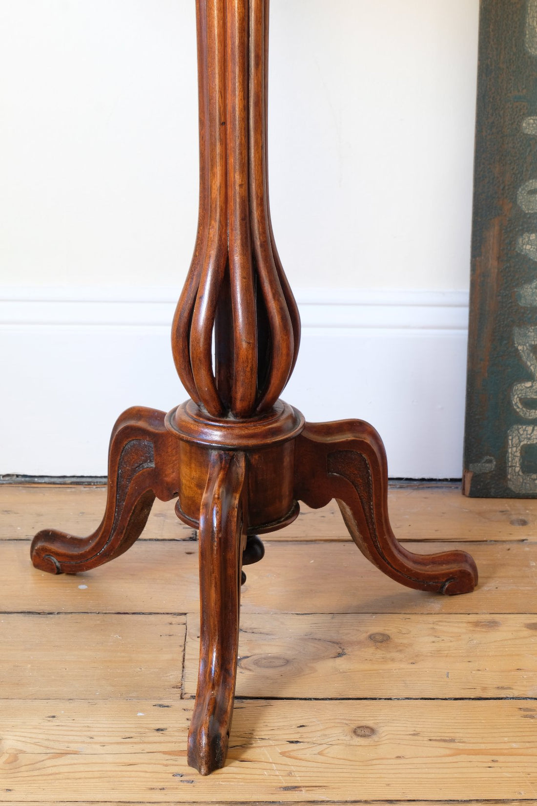 close up of a Late Victorian mahogany oval tilt-top tripod table with open reed column detail