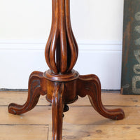 close up of a Late Victorian mahogany oval tilt-top tripod table with open reed column detail