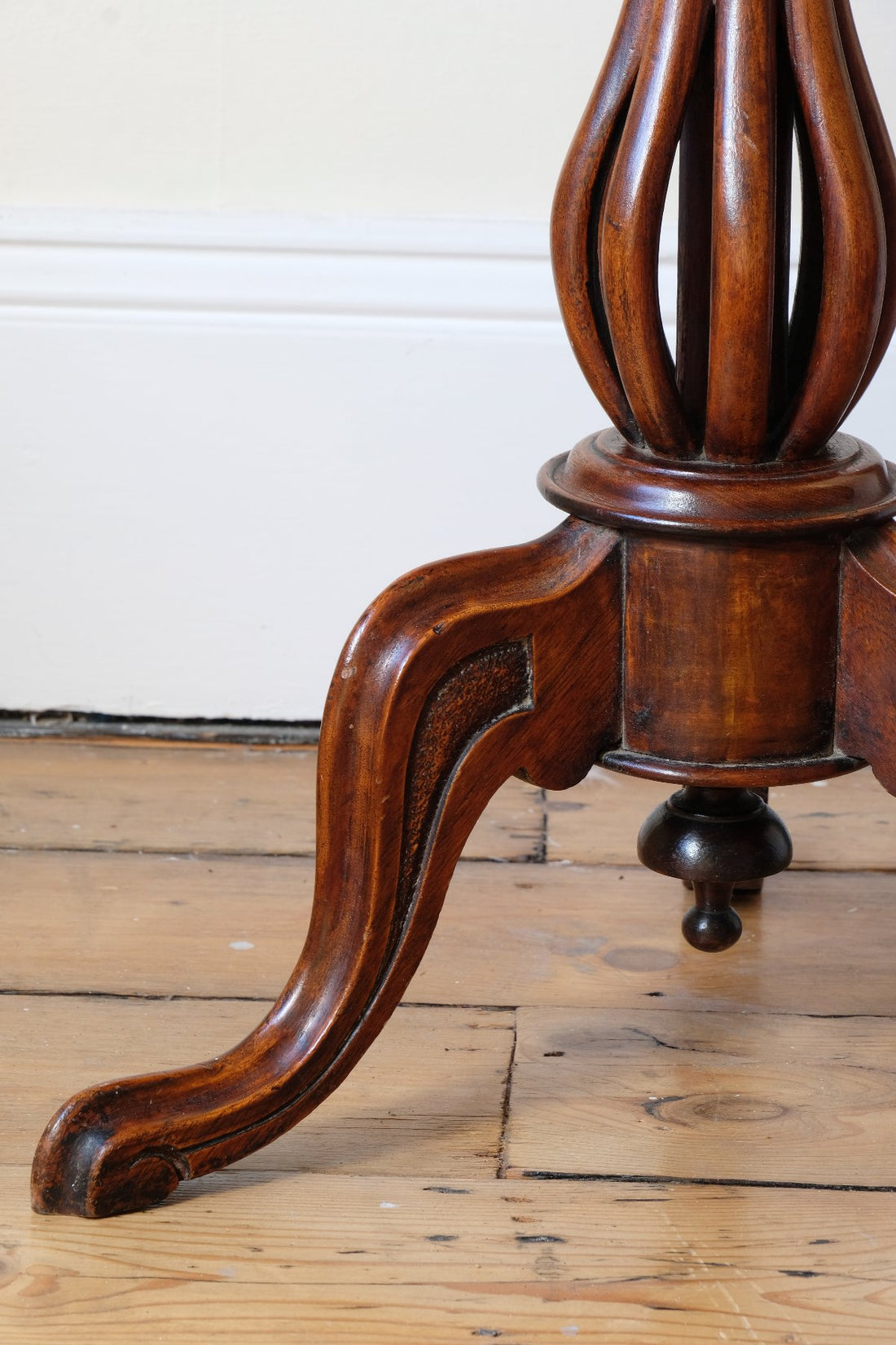 carved cabriole legs on a Late Victorian mahogany oval tilt-top tripod table with open reed column detail