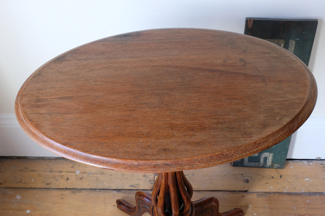 close up of the top on a Late Victorian mahogany oval tilt-top tripod table with open reed column detail