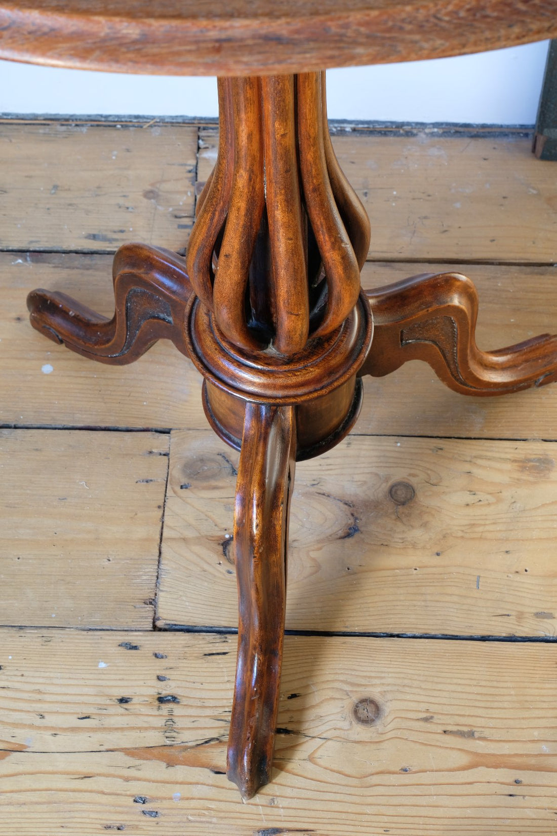 Downward view on a Late Victorian mahogany oval tilt-top tripod table with open reed column detail