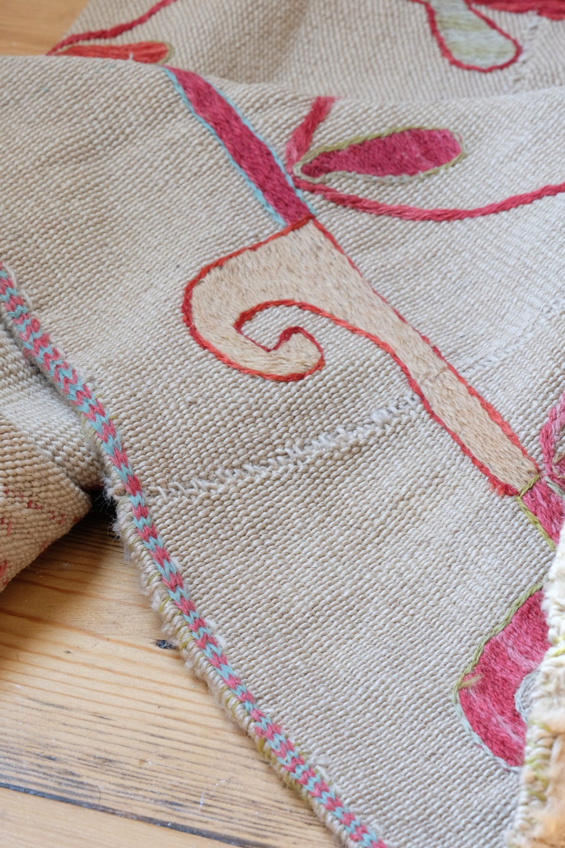 Close up edge detail on a Large Uzbek Suzani embroidered textile silk on cotton floral lattice design