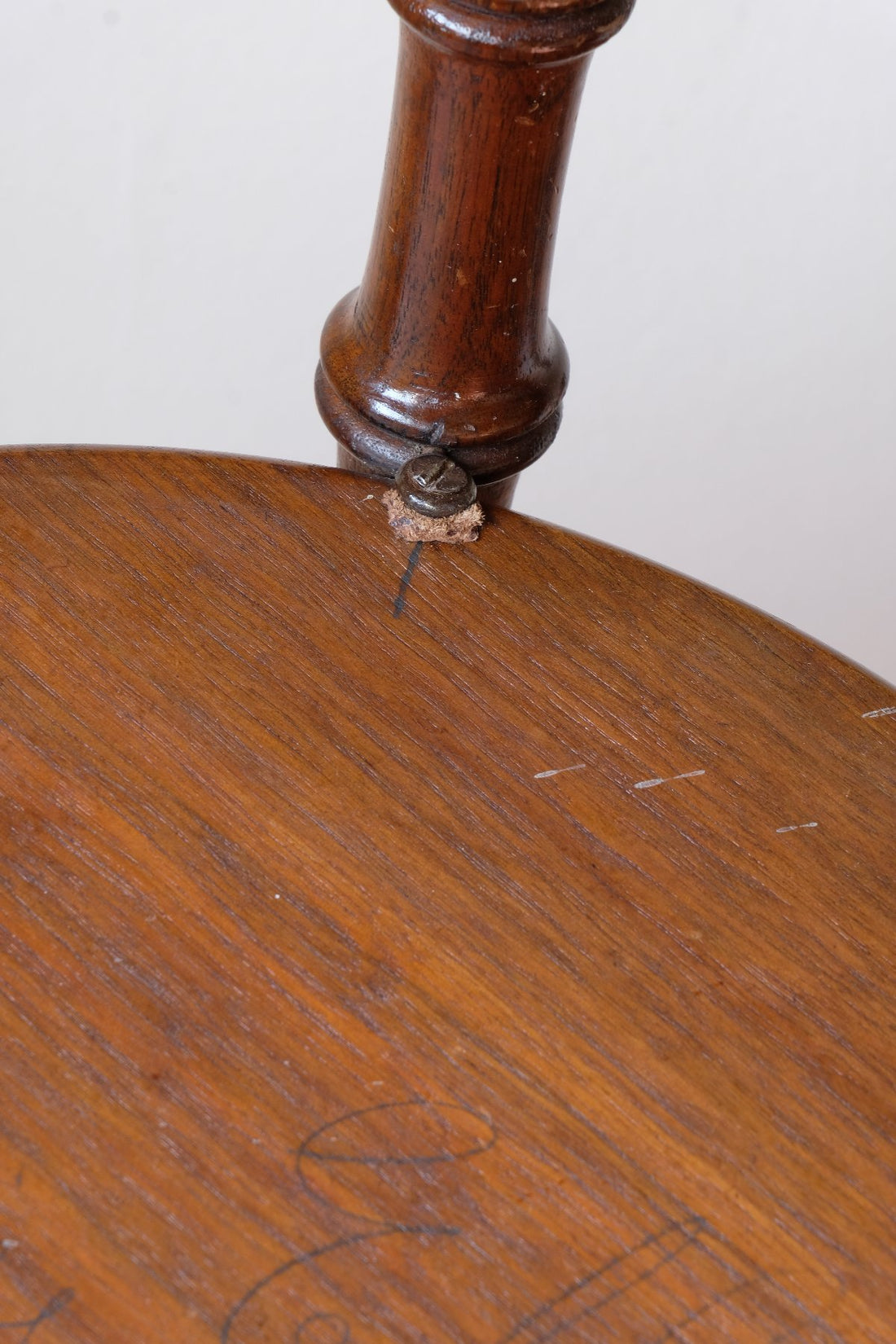 Leather washer and original pencil mark to align the under tier and eye ley and screw o a Victorian mahogany cricket table with faux bamboo legs and two-tone finish