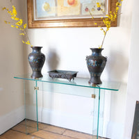 Modern glass hall table with sculptural metal V-shaped base in Leon Rosen style