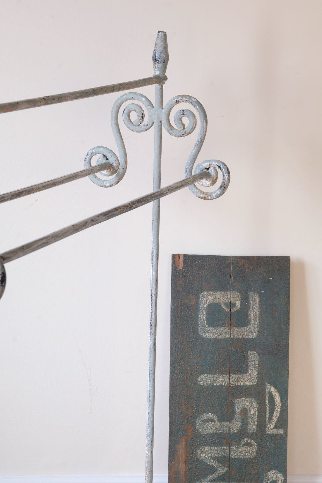 close up - Early 20th century wrought iron freestanding towel rail with scroll ends and aged painted finish