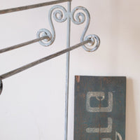 close up - Early 20th century wrought iron freestanding towel rail with scroll ends and aged painted finish