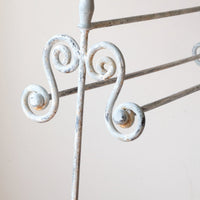 close up of scroll work and finial - Early 20th century wrought iron freestanding towel rail with scroll ends and aged painted finish