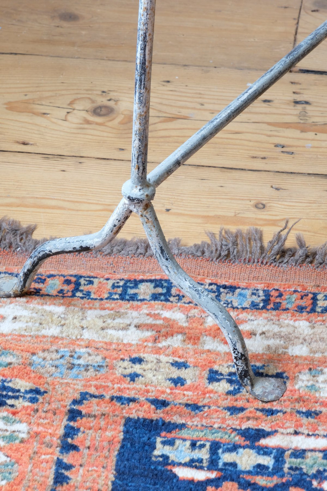 Cloe up of feet and legs - Early 20th century wrought iron freestanding towel rail with scroll ends and aged painted finish
