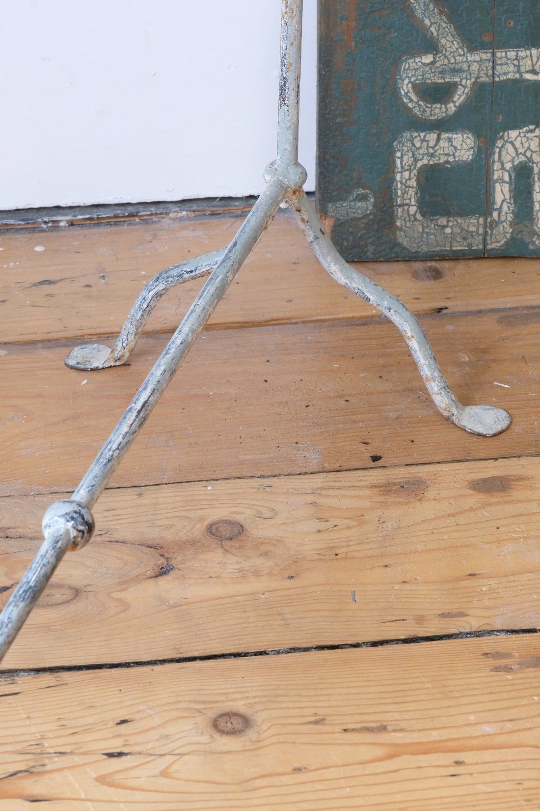 Close up of feet - Early 20th century wrought iron freestanding towel rail with scroll ends and aged painted finish