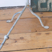 Close up of feet - Early 20th century wrought iron freestanding towel rail with scroll ends and aged painted finish