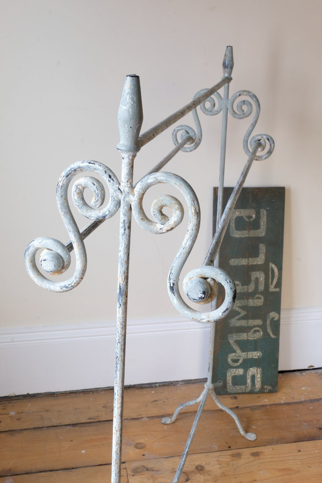 Early 20th century wrought iron freestanding towel rail with scroll ends and aged painted finish