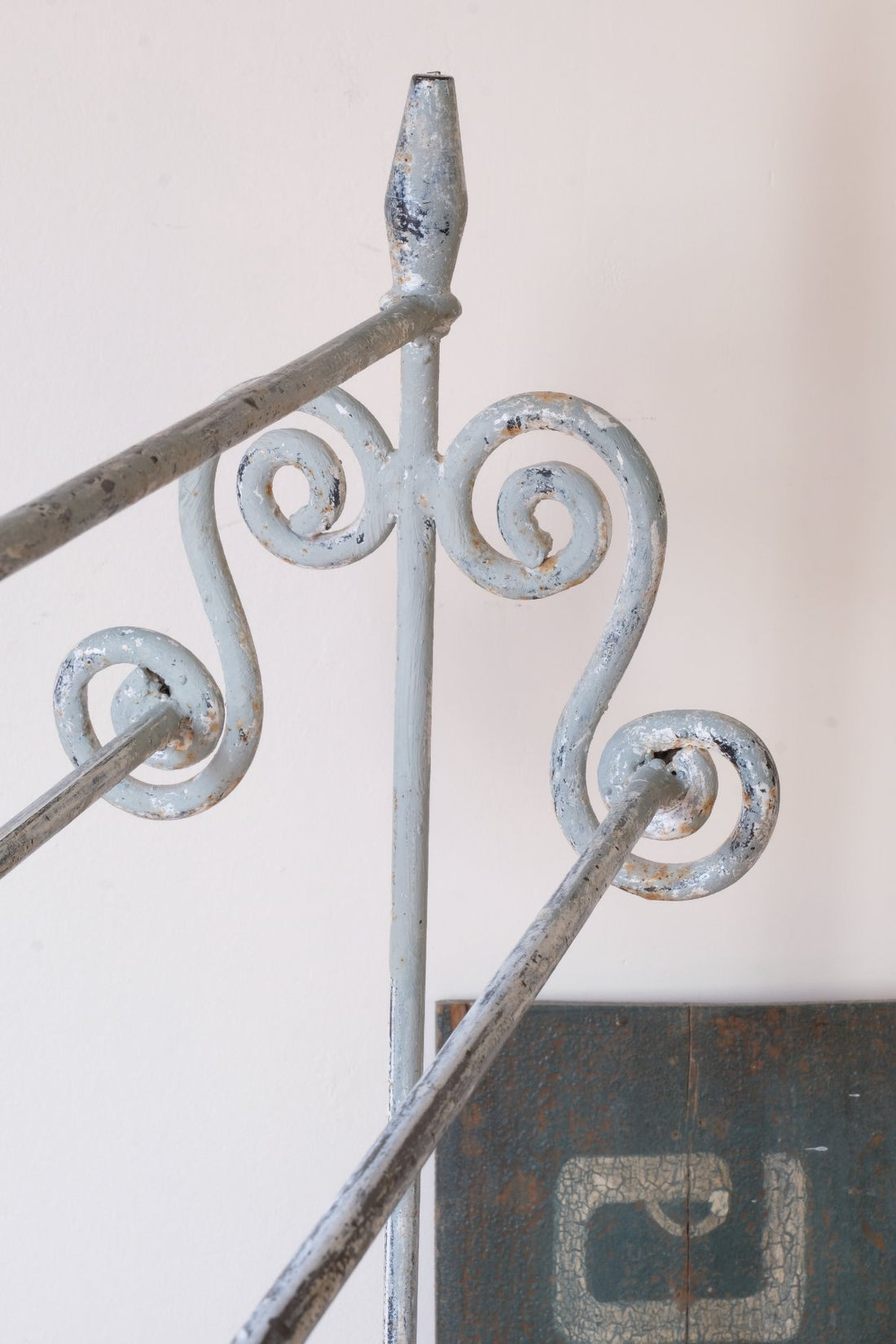 Early 20th century wrought iron freestanding towel rail with scroll ends and aged painted finish