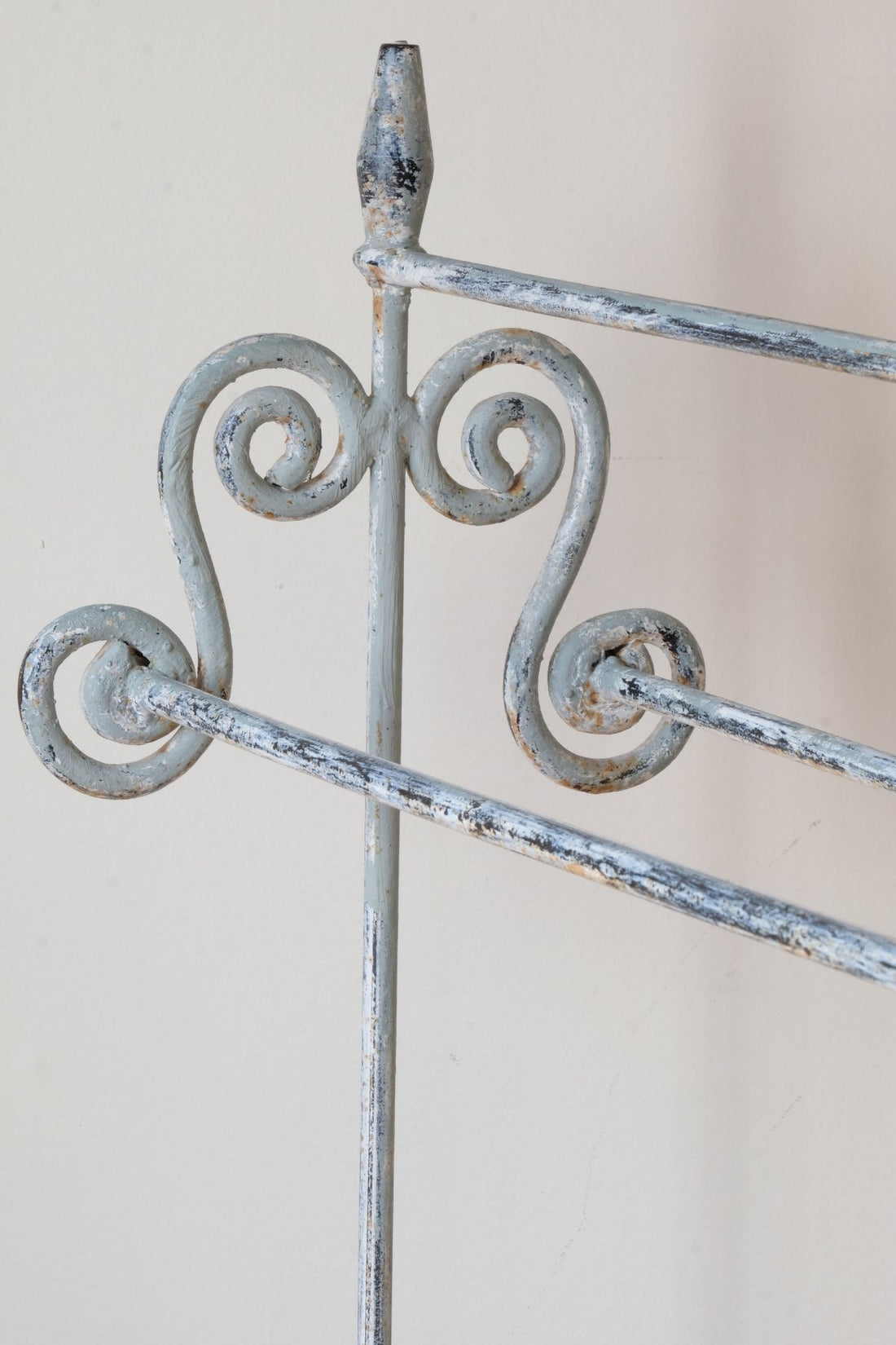 Early 20th century wrought iron freestanding towel rail with scroll ends and aged painted finish
