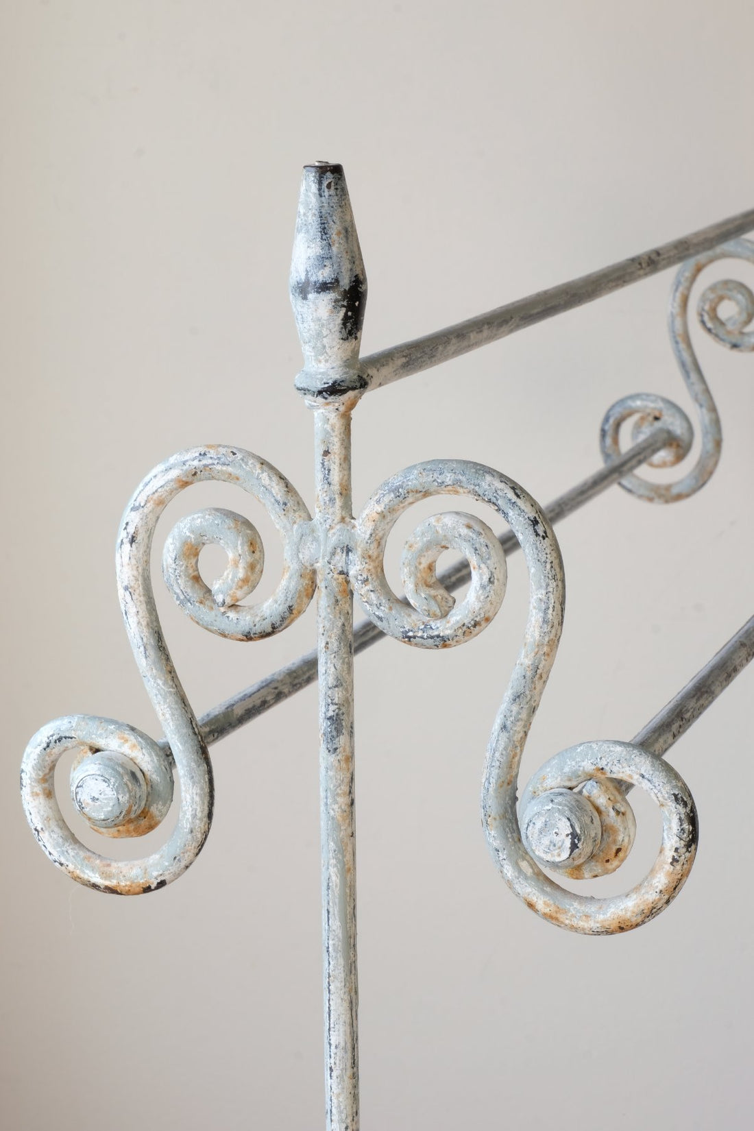 Early 20th century wrought iron freestanding towel rail with scroll ends and aged painted finish