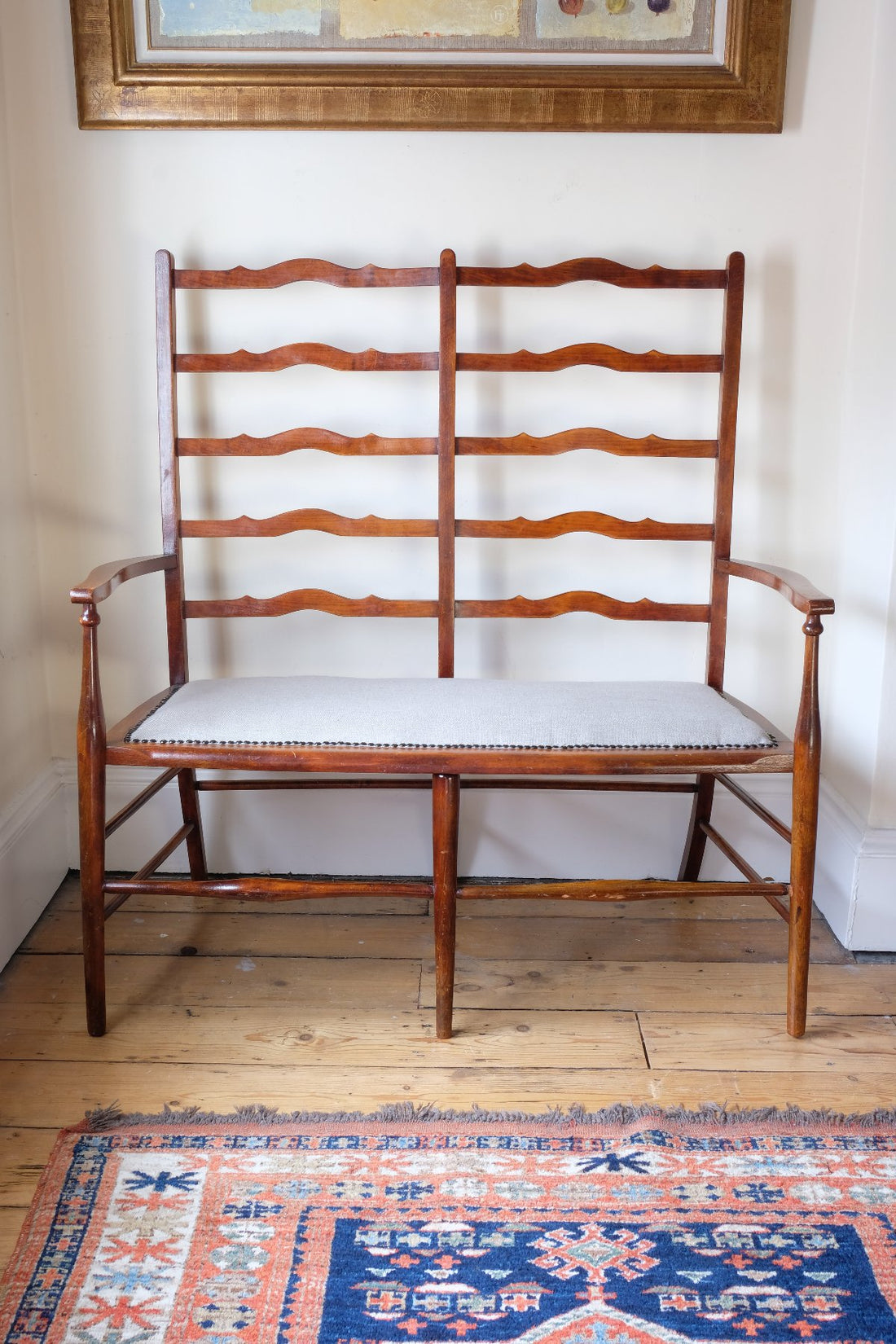 19th century English beech ladder-back bench with linen upholstered horsehair seat and waved slats