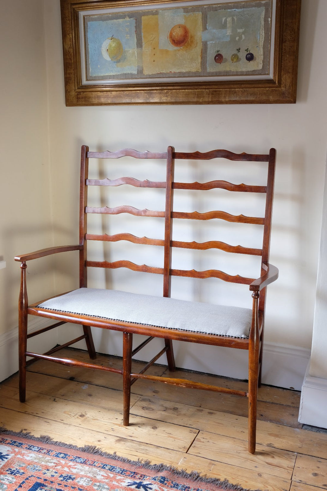 19th century English beech ladder-back bench with linen upholstered horsehair seat and waved slats