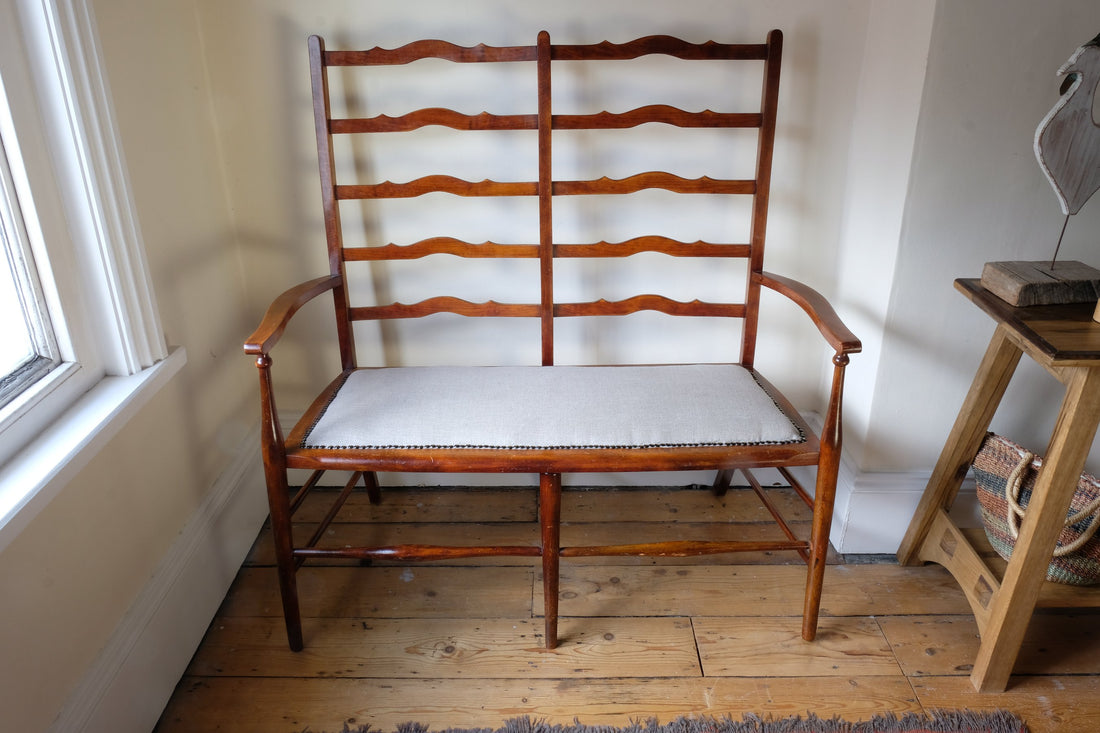 19th century English beech ladder-back bench with linen upholstered horsehair seat and waved slats