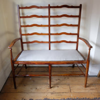 19th century English beech ladder-back bench with linen upholstered horsehair seat and waved slats