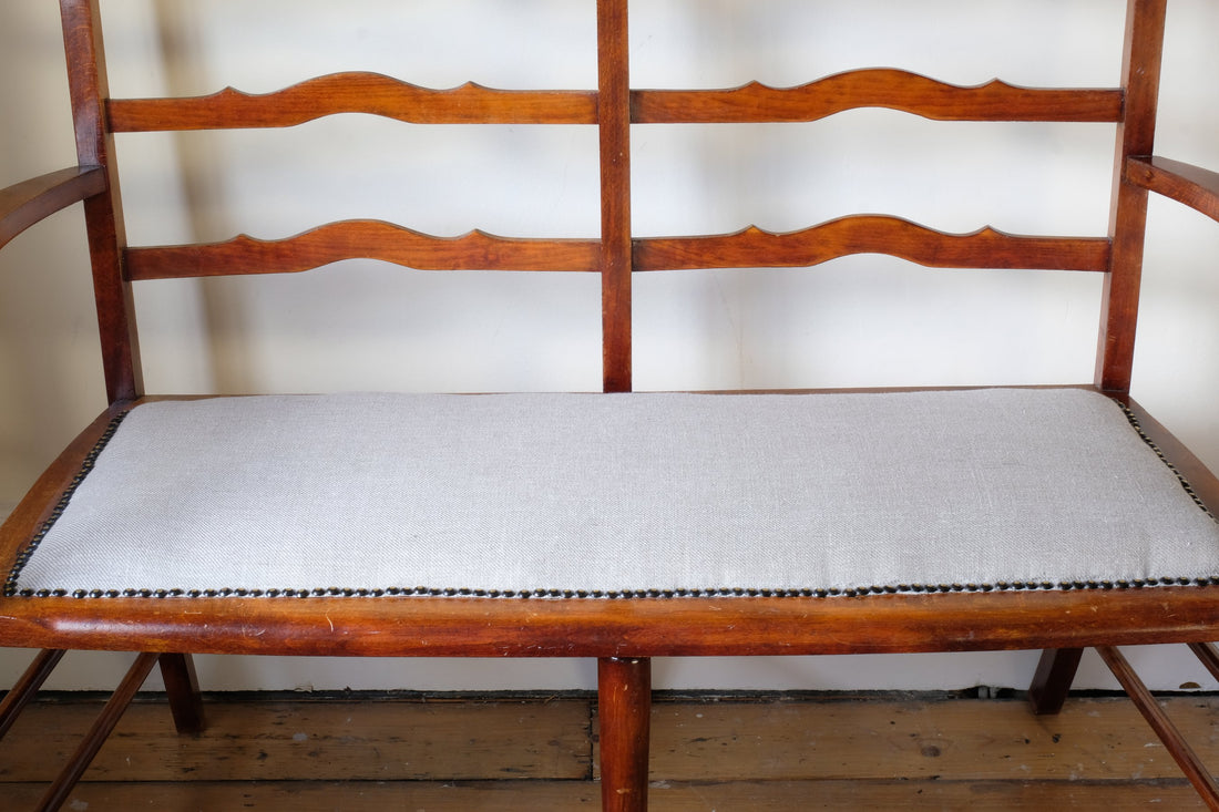 19th century English beech ladder-back bench with linen upholstered horsehair seat and waved slats