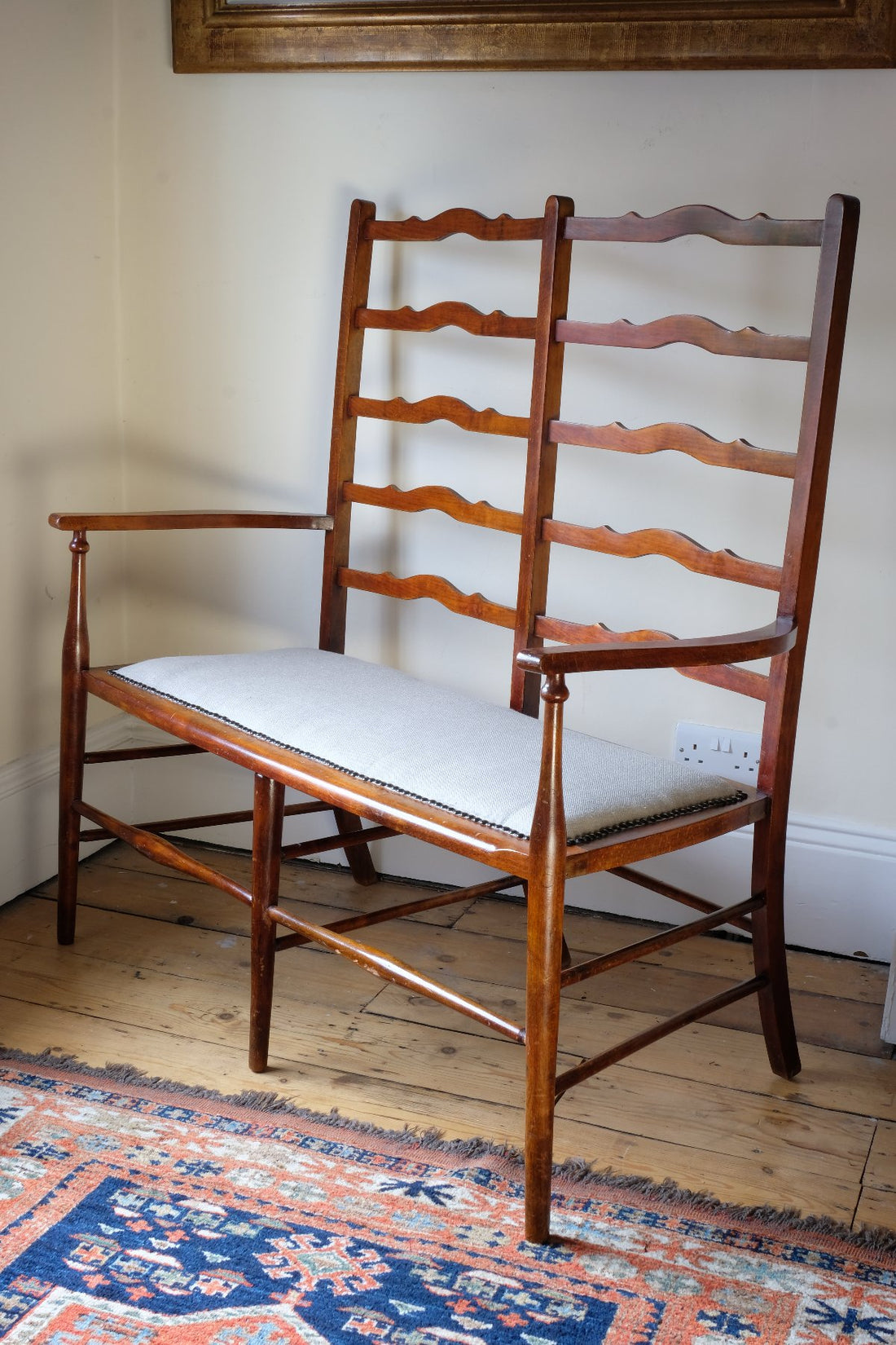 19th century English beech ladder-back bench with linen upholstered horsehair seat and waved slats