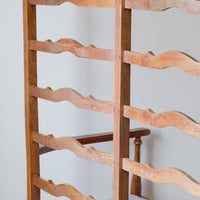 Close up back view of a 19th century English beech ladder-back bench with linen upholstered horsehair seat and waved slats