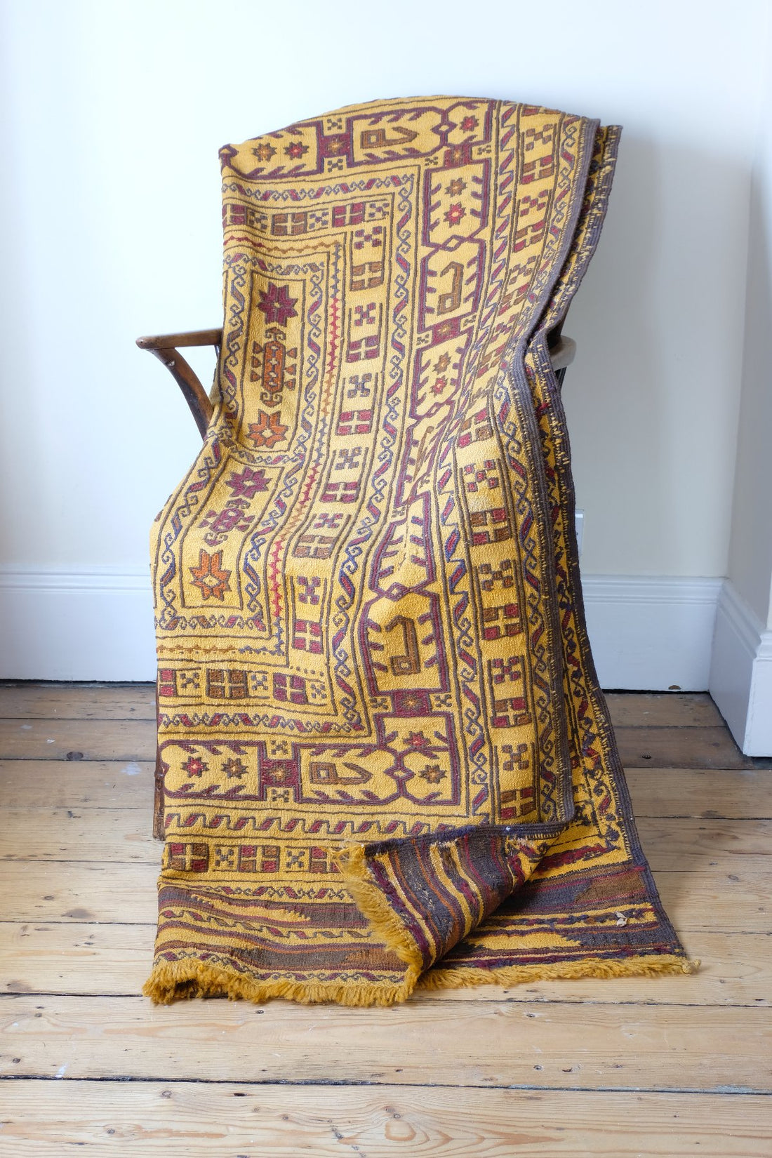 folded ober a chair and turned corner to see the back - Antique Anatolian kilim rug with saffron ground and geometric motifs