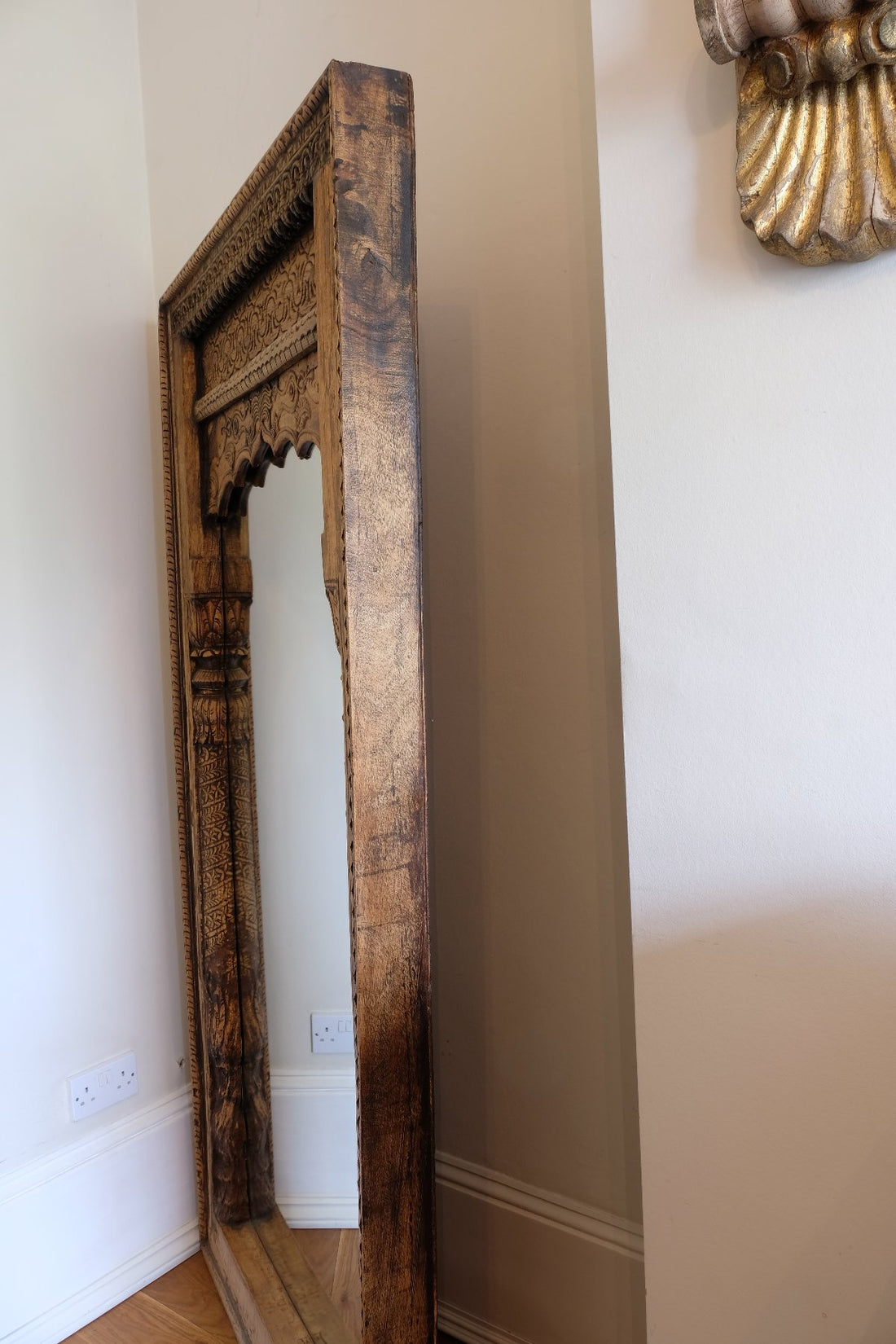 side view on a large antique Indian carved hardwood mirror with Indo-Islamic Moorish arch detail