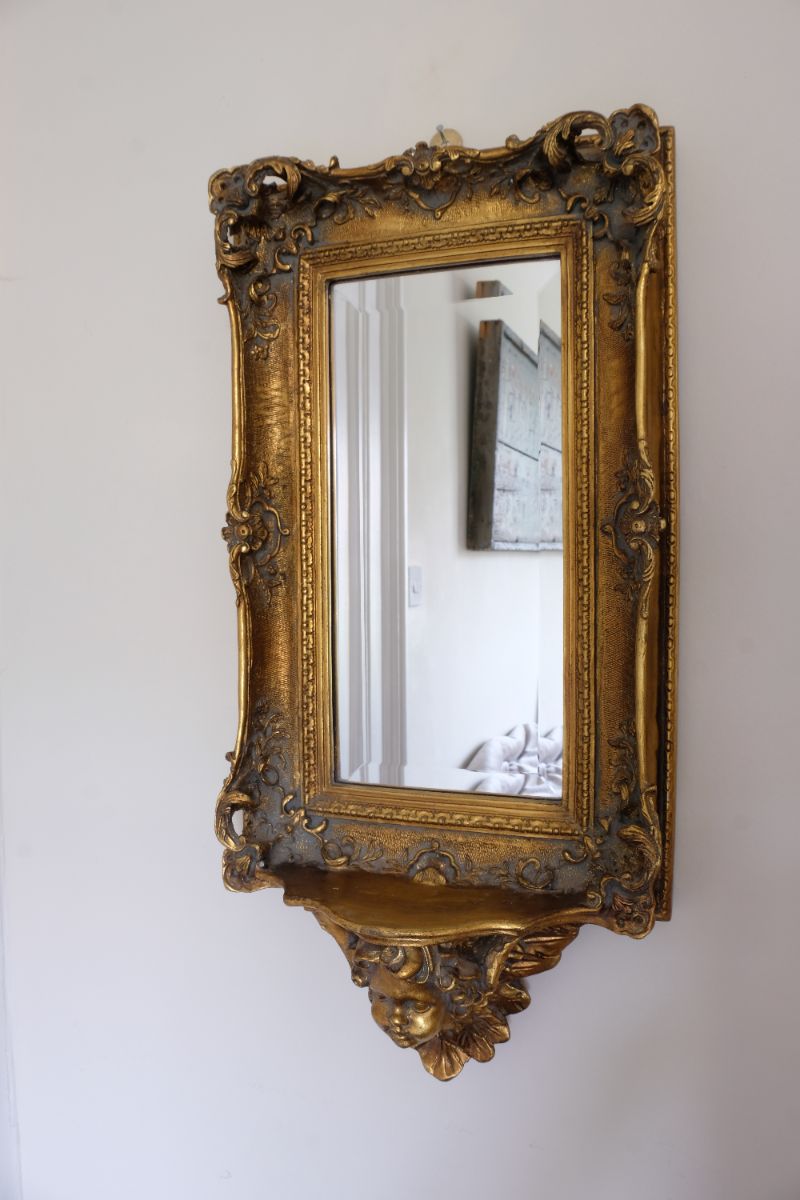 Late Victorian gilt wall mirror with original bevelled mirror plate and cherub shelf detail