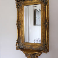 Late Victorian gilt wall mirror with original bevelled mirror plate and cherub shelf detail
