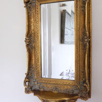 Late Victorian gilt wall mirror with original bevelled mirror plate and cherub shelf detail