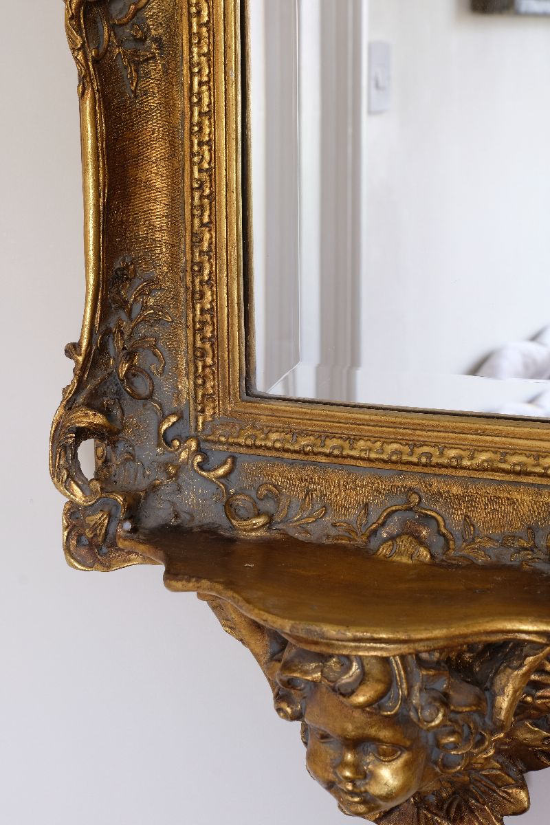 Cloes up of the pierced detail on a  Late Victorian gilt wall mirror with original bevelled mirror plate and cherub shelf detail