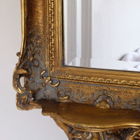 Cloes up of the pierced detail on a  Late Victorian gilt wall mirror with original bevelled mirror plate and cherub shelf detail