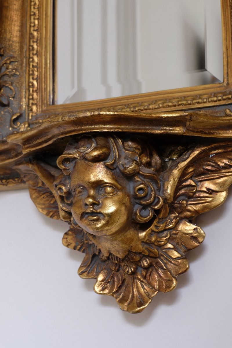 Late Victorian gilt wall mirror with original bevelled mirror plate and cherub shelf detail