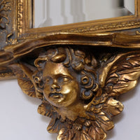 Late Victorian gilt wall mirror with original bevelled mirror plate and cherub shelf detail