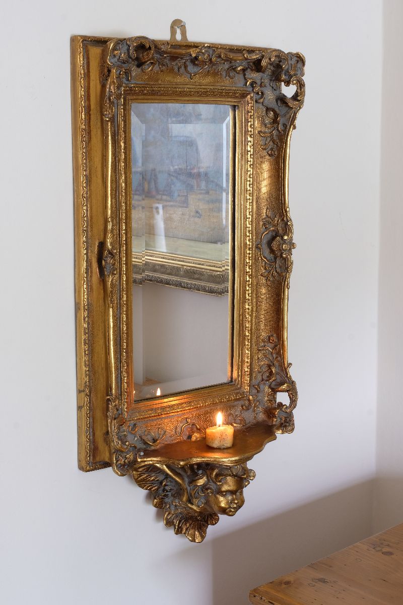 Late Victorian gilt wall mirror with original bevelled mirror plate and cherub shelf detail