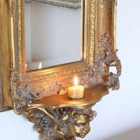 Late Victorian gilt wall mirror with original bevelled mirror plate and cherub shelf detail
