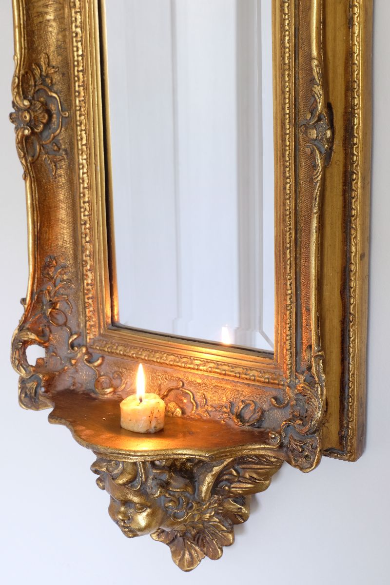 Late Victorian gilt wall mirror with original bevelled mirror plate and cherub shelf detail