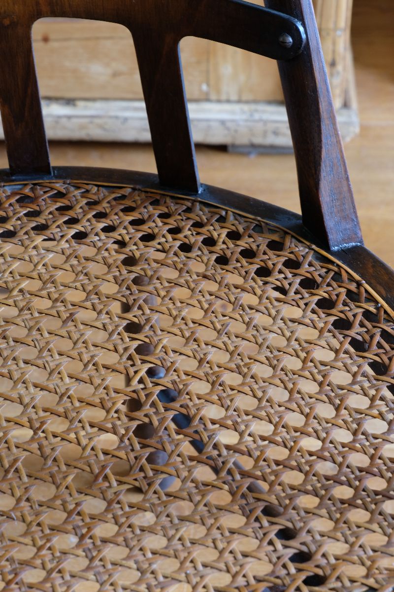 Close up view of the cane seat on a Rare Edwardian bentwood lattice back armchair attributed to Jas Shoolbred with pierced Arts & Crafts design 