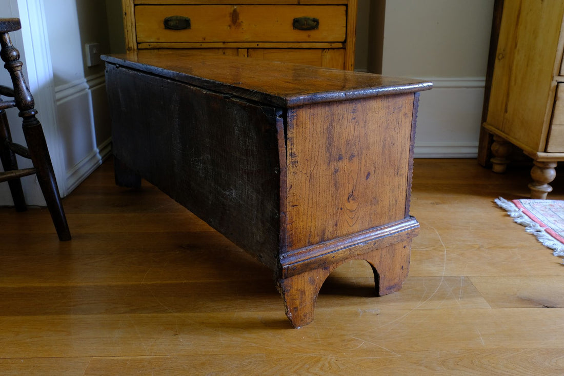 Side view of the raised plint on a Early 19th Century English Elm Six Plank Coffer Chest With Internal Till