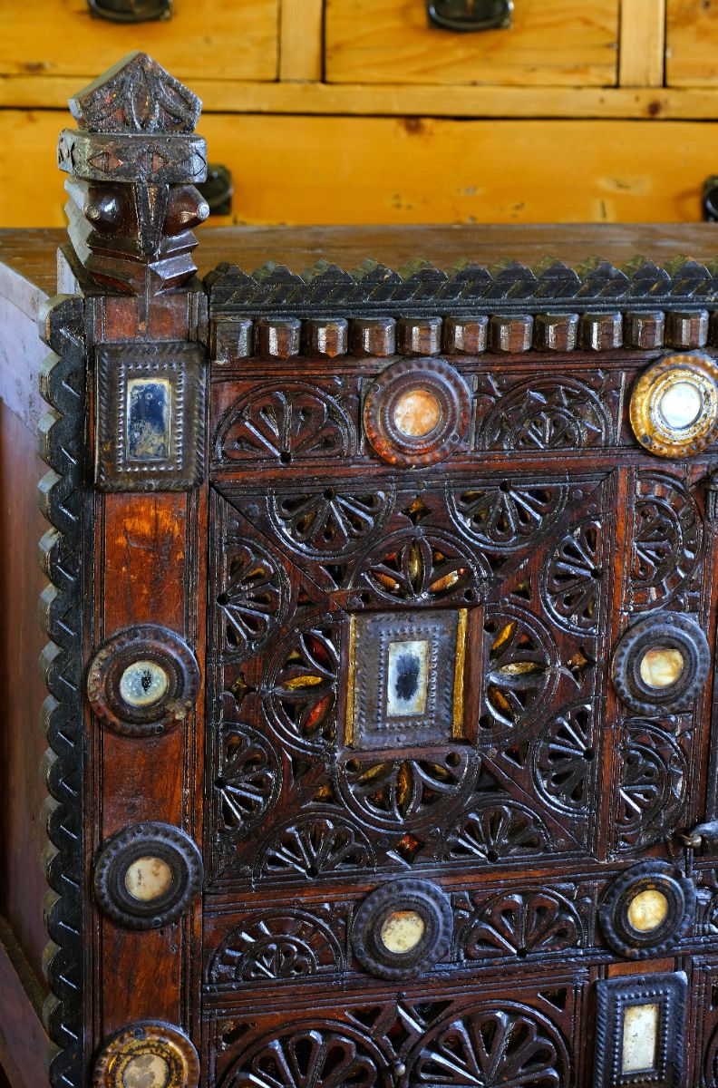 Architectural cresting with carved corner finials on an Antique Kutch Damchiya dowry chest with mirror inlay and carved hardwood fretwork, Gujarat c.1900–1930