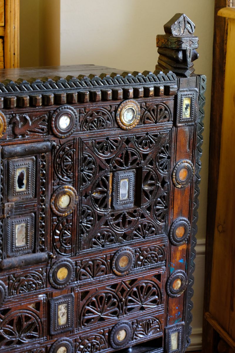 Architectural cresting with carved corner finials on an Antique Kutch Damchiya dowry chest with mirror inlay and carved hardwood fretwork, Gujarat c.1900–1930