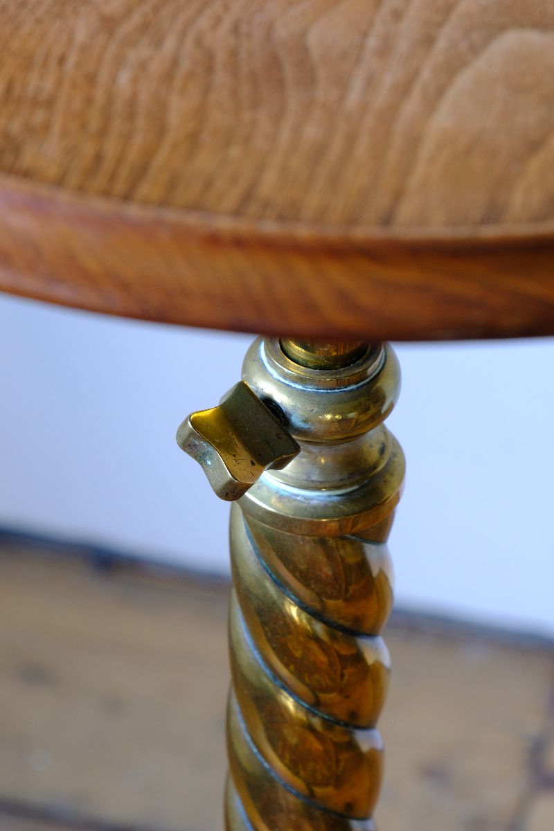 close up of the brass locking thumb screw on an Antique Victorian brass telescopic wine table with mahogany top and lion’s paw feet