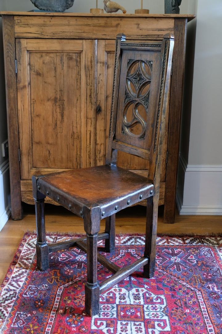 Carved elm hall chair circa 1900 with hide seat front view