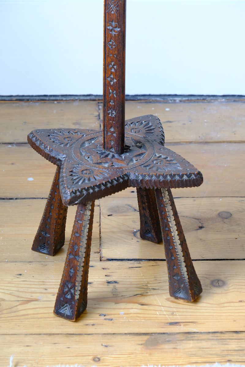 Star shaped carved base of a Rare Arts & Crafts Carved Oak Ratchet Adjustable Candle Stand