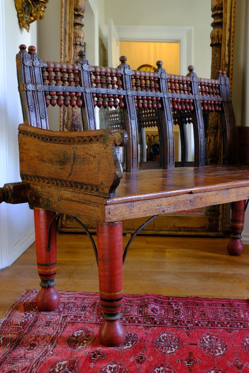 Side carved arm detail on a Late 19th Century Gujarati Hardwood Hall Bench with Original Polychrome Finish, Turned Gallery Back and Brass Rosette Mounts 