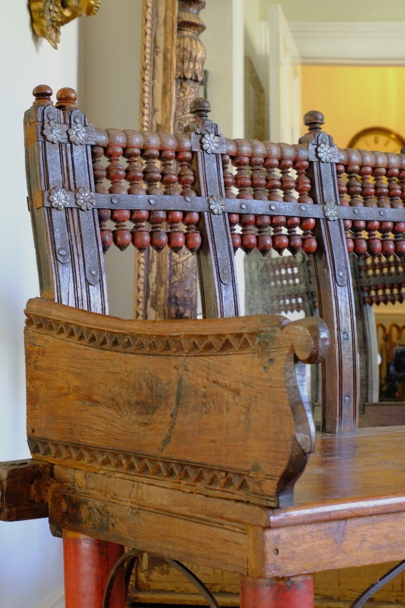 Close up side view on a Late 19th Century Gujarati Hardwood Hall Bench with Original Polychrome Finish, Turned Gallery Back and Brass Rosette Mounts